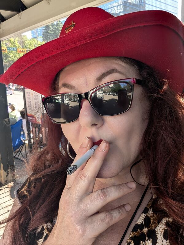 Tammy Tenacious Turner in a red cowboy hat and sunglasses